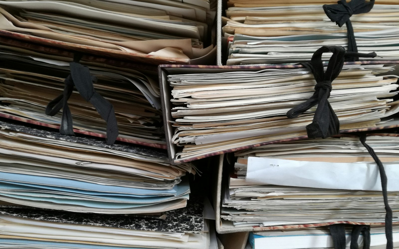 紐で束ねられて積み重なった古い書類の束——許諾範囲が分からない過去の素材